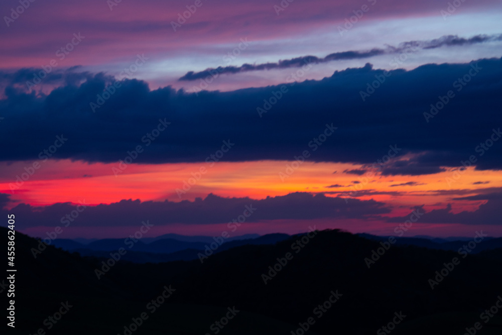 Fototapeta premium sunset, mountains, valleys, landscape, golden hour, orange sky. blue and orange sky