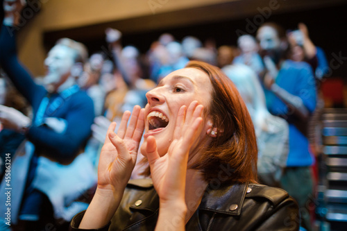 Smiling, enthusiastic woman cheering in audience photo