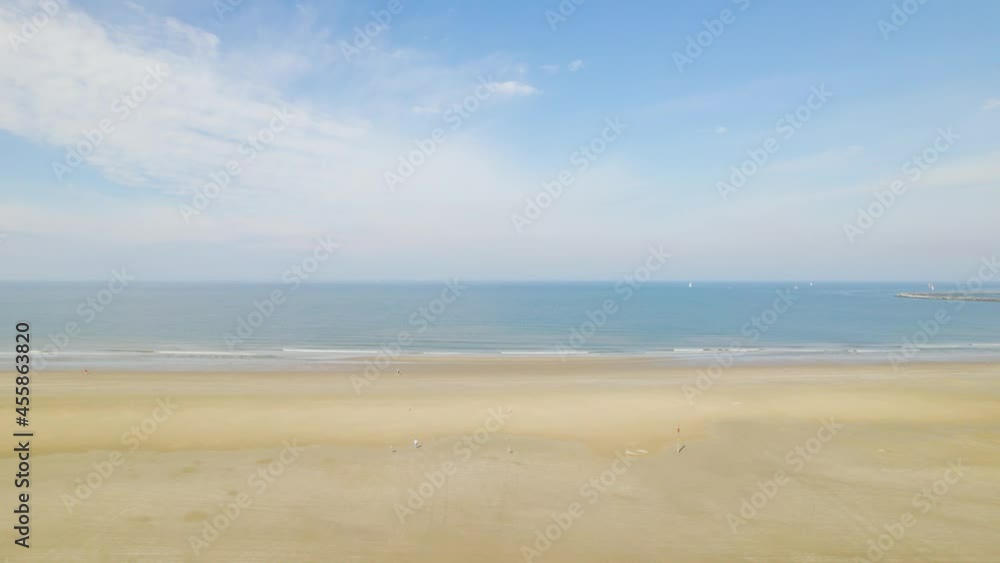 Rising aerial view over beach approaching ocean and blue sky Rising aerial view over beach approaching ocean and blue sky