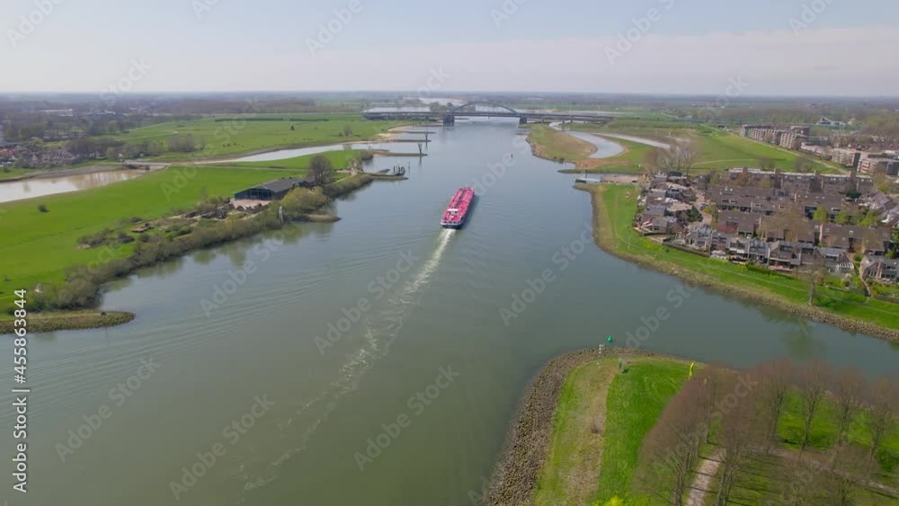 Reversing rising aerial view of red boat on ricer in Dutch countryside Reversing rising aerial view of red boat on ricer in Dutch countryside