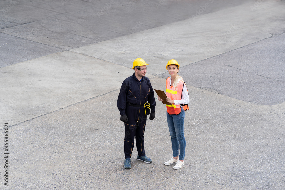 Portrait of foreman or supervisor in uniform and wearing yellow safety helmet checking products on document paper before control loading container box from cargo freight ship for import export. cargo Portrait of foreman or supervisor in uniform and wearing yellow safety helmet checking products on document paper before control loading container box from cargo freight ship for import export. cargo