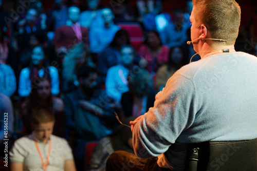 Audience watching male speaker in wheelchair talking on stage