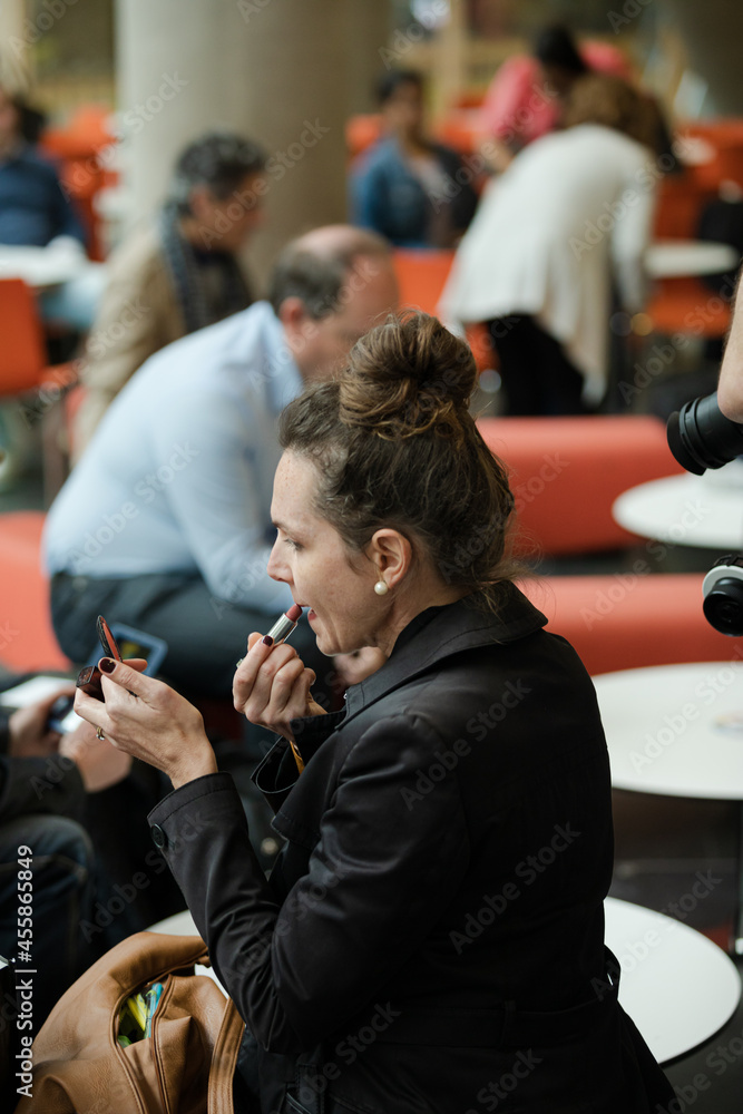 Woman applying make up in hall of auditorium Woman applying make up in hall of auditorium