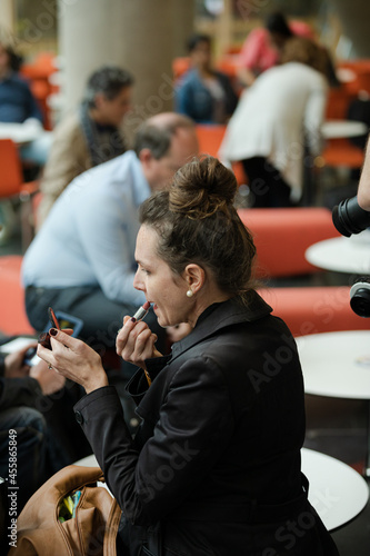 Woman applying make up in hall of auditorium