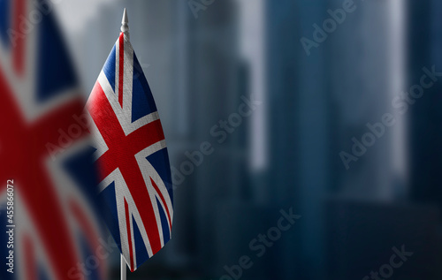 Fototapeta Small flags of United Kingdom on a blurry background of the city