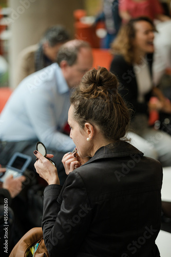 Woman applying make up in hall of auditorium