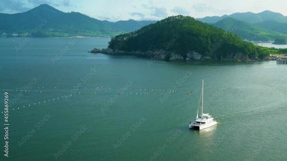 Sailing Catamaran Yacht At Serene Seascape Near Hanwha Resort Geoje Belvedere, Geoje Island, South Korea. - Wide Shot Sailing Catamaran Yacht At Serene Seascape Near Hanwha Resort Geoje Belvedere, Geoje Island, South Korea. - Wide Shot