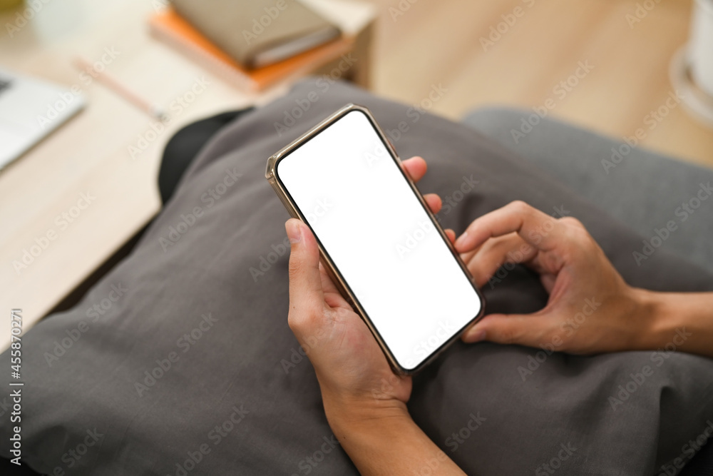 Close up view man using smart phone and sitting on couch. Close up view man using smart phone and sitting on couch.