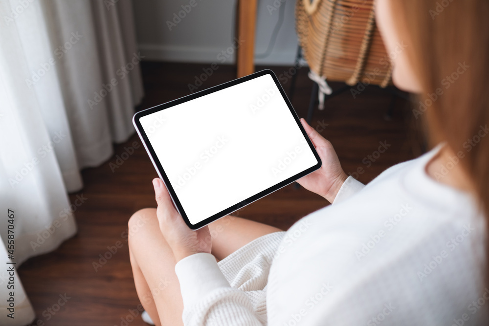 Mockup image of a woman holding digital tablet with blank desktop screen at home Mockup image of a woman holding digital tablet with blank desktop screen at home