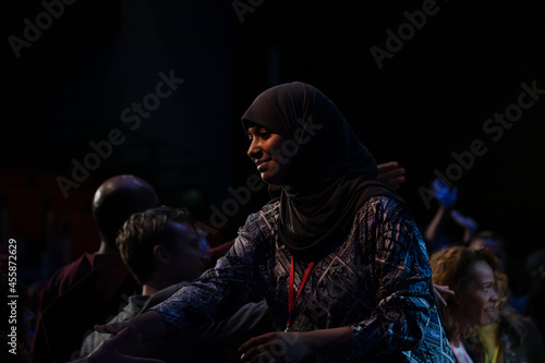 Audience reaching for female speaker in hijab