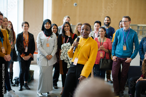 Smiling female speaker with microphone on stage