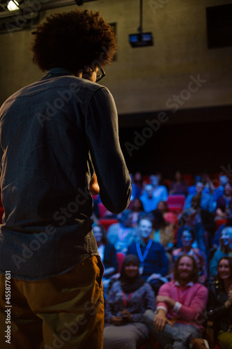 Male speaker on stage talking to audience