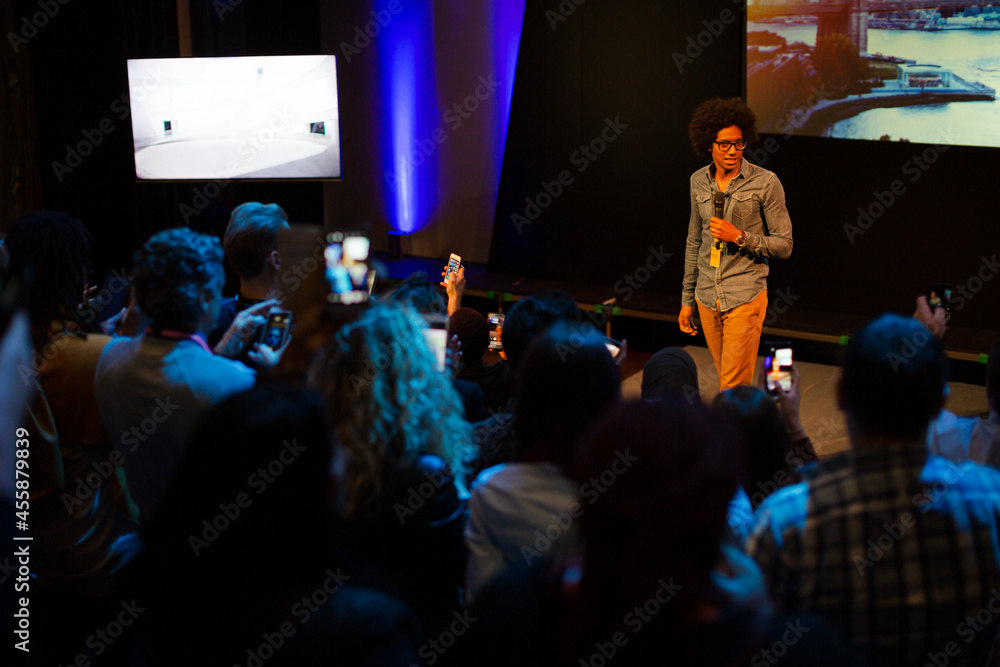Male speaker with microphone talking to audience Male speaker with microphone talking to audience