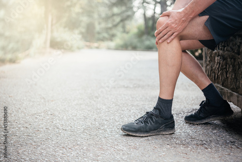 Senior man having knee pain while exercising, sports injuries concept