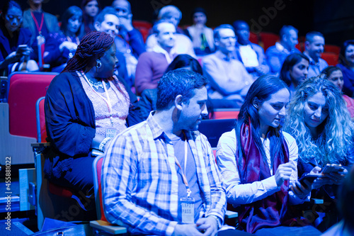 Man and woman with smart phone in conference audience