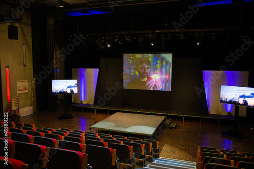 Projection screens and seats in empty conference auditorium