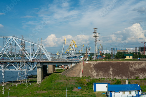 The loose abutment of the railway bridge against the background of harbor cranes.