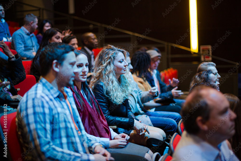 Man and woman with with smart phone in conference audience