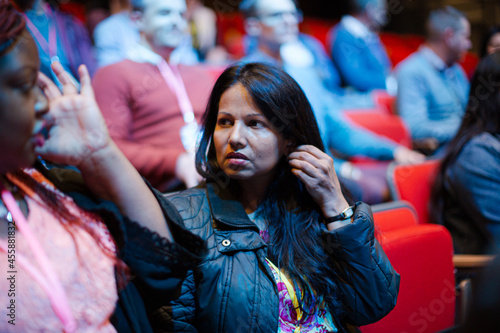 Attentive woman listening in conference audience © KOTO