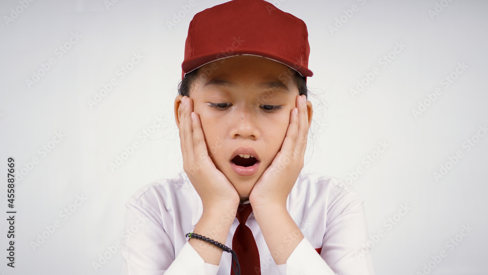 Elementary school asian girl who is surprised what she sees isolated on white background Elementary school asian girl who is surprised what she sees isolated on white background
