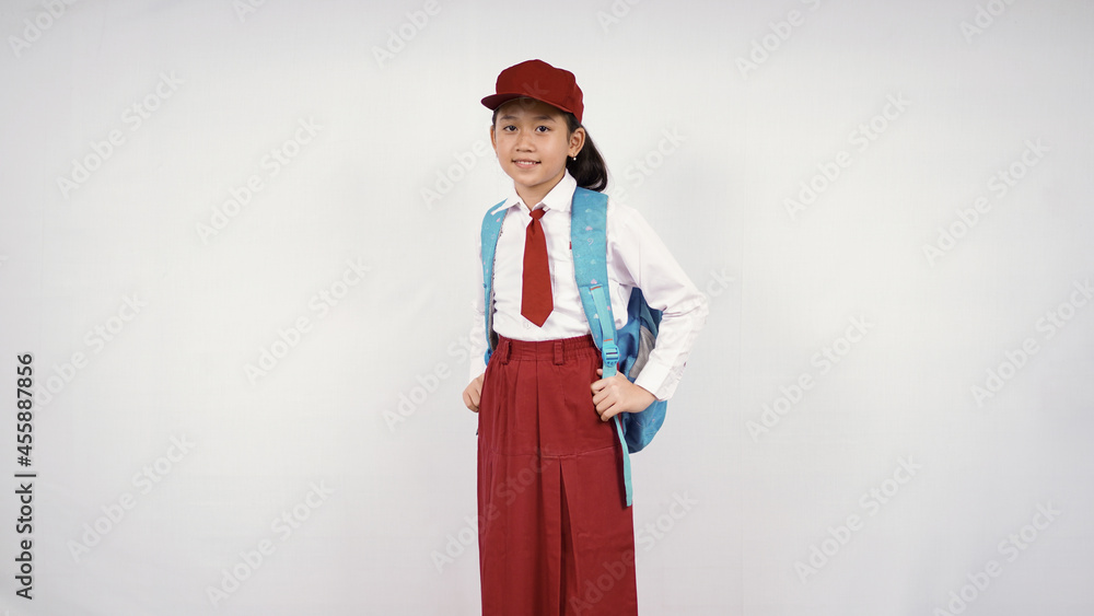 asian little girl wearing hat and school bag smiling happily on white background isolated