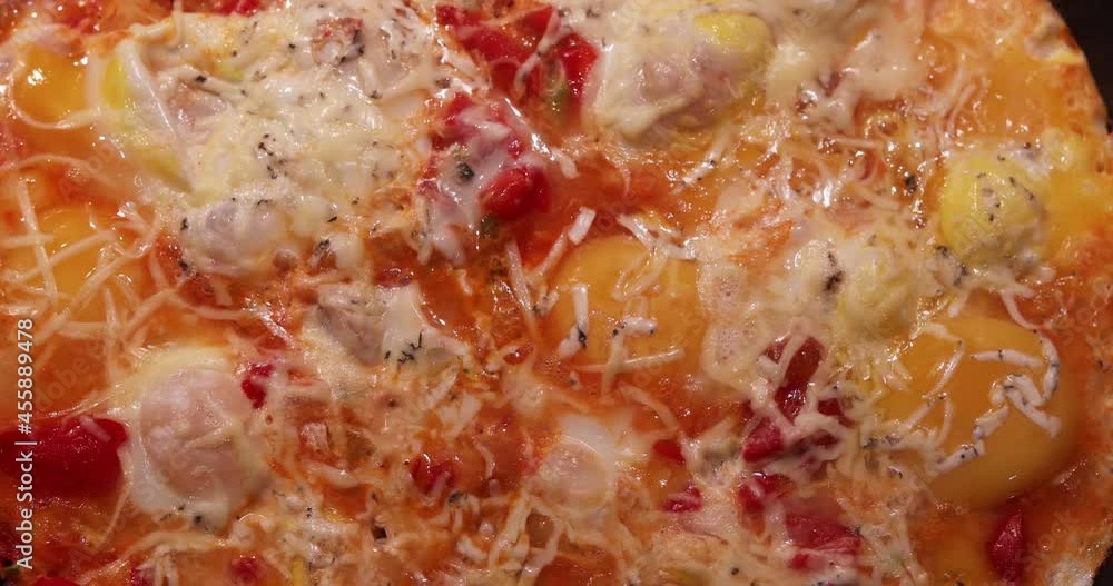 Blurred Background Of Cooking Fried Eggs With Tomatoes, Cheese And Vegetables In A Frying Pan, Flat Lay Blurred Background Of Cooking Fried Eggs With Tomatoes, Cheese And Vegetables In A Frying Pan, Flat Lay