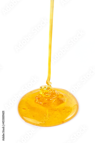 Pouring honey isolated on white background. Honey or caramel drop.