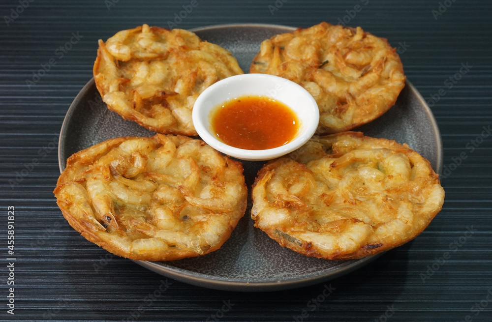 deep fried crispy golden fresh prawn fritter pan cake in round shape on dark grey wood background dim sum halal menu deep fried crispy golden fresh prawn fritter pan cake in round shape on dark grey wood background dim sum halal menu
