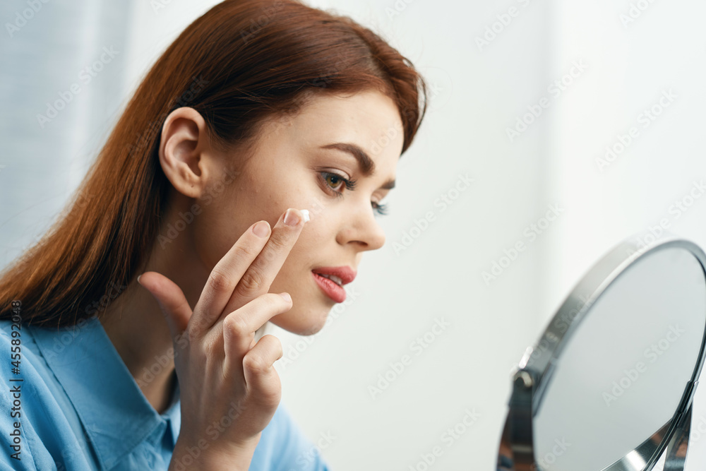 woman looking in the mirror cosmetics personal care woman looking in the mirror cosmetics personal care