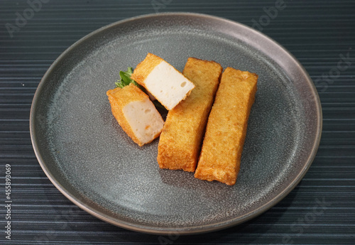 deep fried long golden stick salmon fish seafood paste cake on dark grey wood background dim sum halal menu