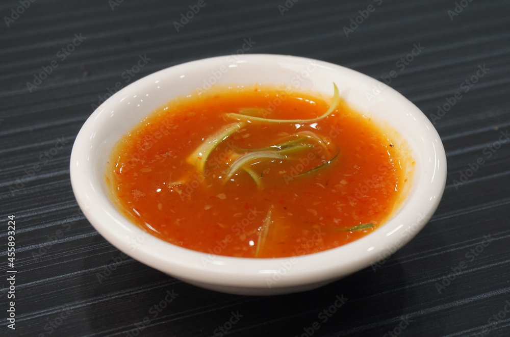 homemade garlic spicy chilli sauce in white plate on dark grey wood background dim sum halal menu homemade garlic spicy chilli sauce in white plate on dark grey wood background dim sum halal menu