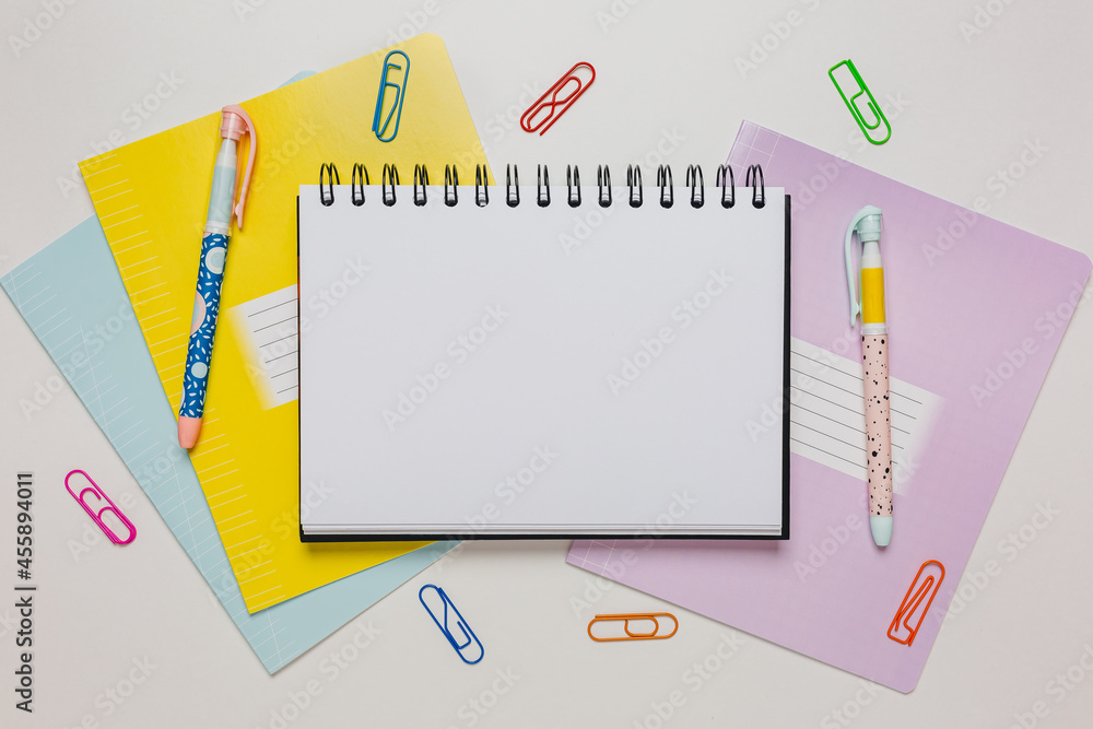 Notepad, exercise book and pen on the desk. Mock up in copy space office on white background. Back to school Notepad, exercise book and pen on the desk. Mock up in copy space office on white background. Back to school