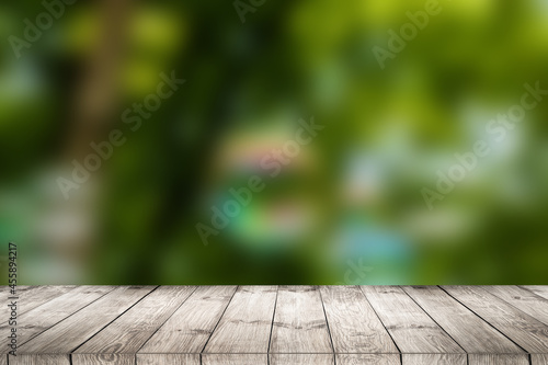 Empty of wood table top on blur of fresh green abstract from garden. For montage product display or design key visual layout