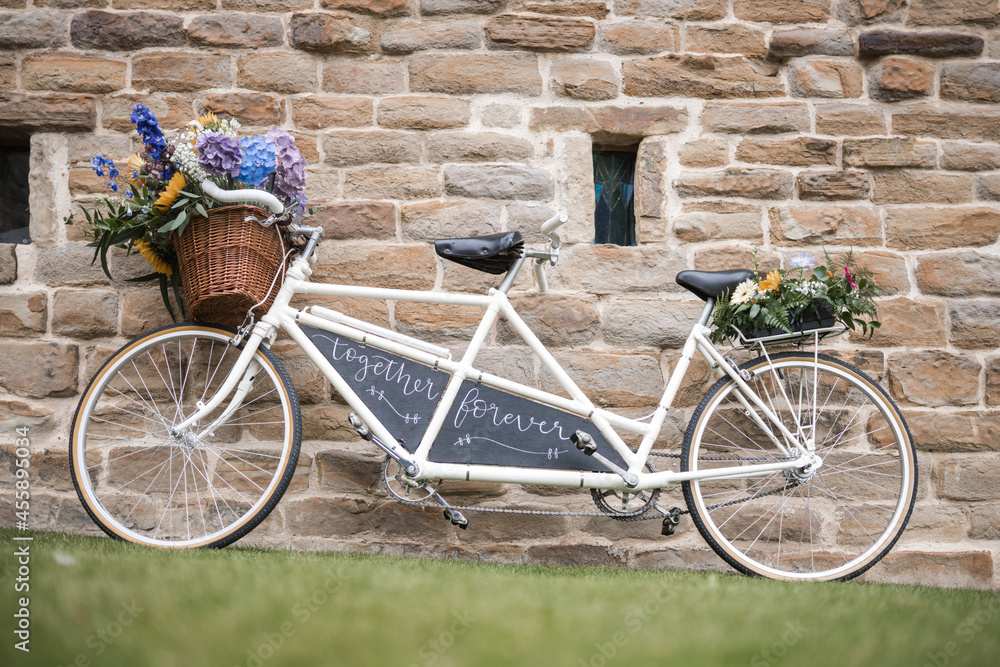 Wedding vintage old retro tandem bike with just married sign and fresh  flowers in woven basket.