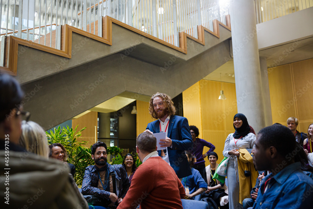 Speaker with microphone talking to audience Speaker with microphone talking to audience