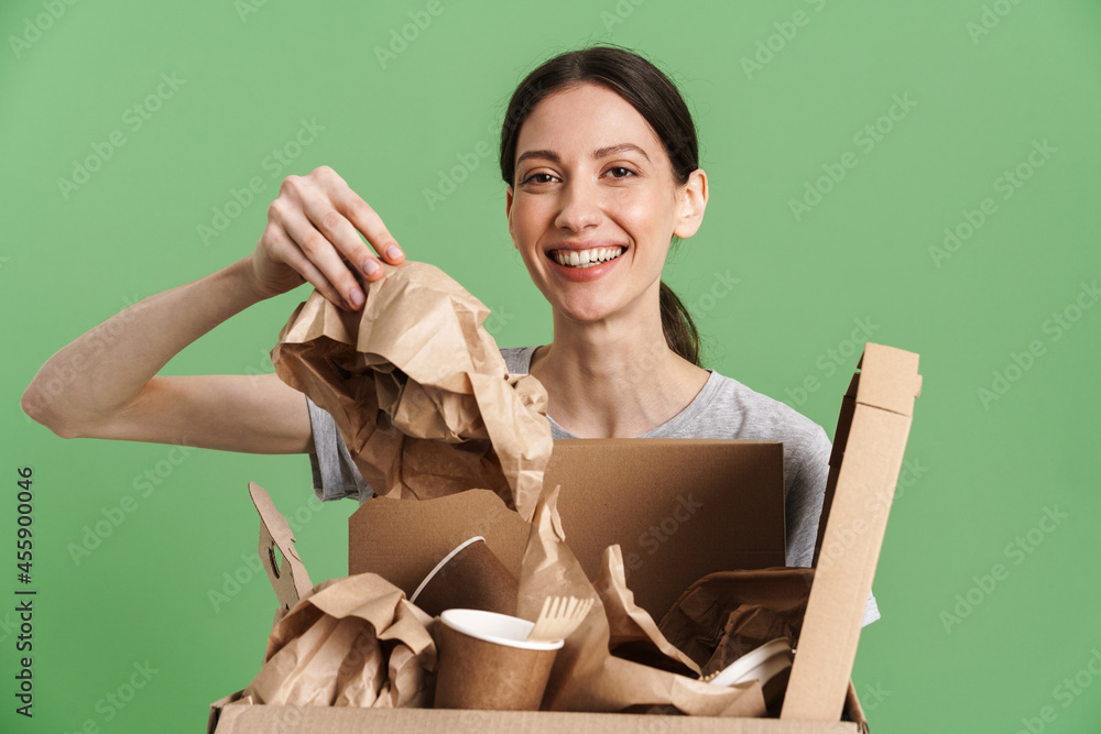 © Drobot Dean - Young brunette woman smiling while posing with paper waste © Drobot Dean - Young brunette woman smiling while posing with paper waste