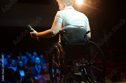 Audience watching speaker in wheelchair talking on stage