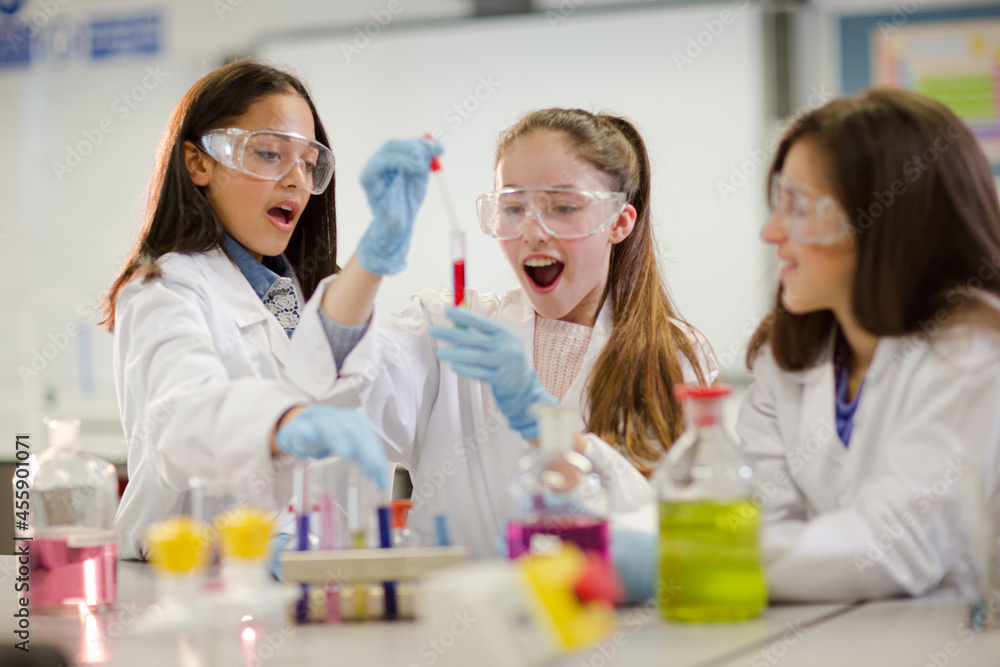 Girl students conducting scientific experiment in laboratory classroom Girl students conducting scientific experiment in laboratory classroom