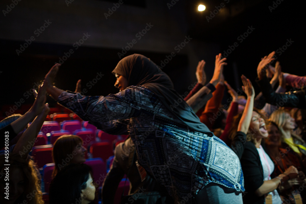Audience reaching for female speaker in hijab