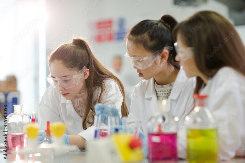 Girl students conducting scientific experiment in laboratory classroom Girl students conducting scientific experiment in laboratory classroom