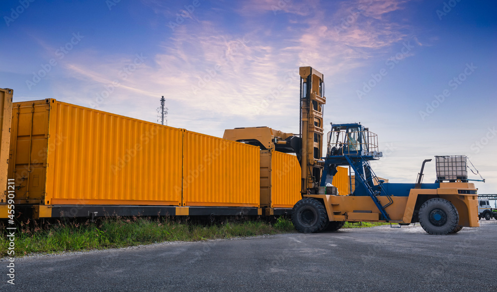 Forklift truck is lifting cargo containers at a train station,railway waiting for distribution terminal goods to aboard are import and export logistic transportation business concept.
