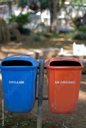 blue and yellow garbage bin in the park photo