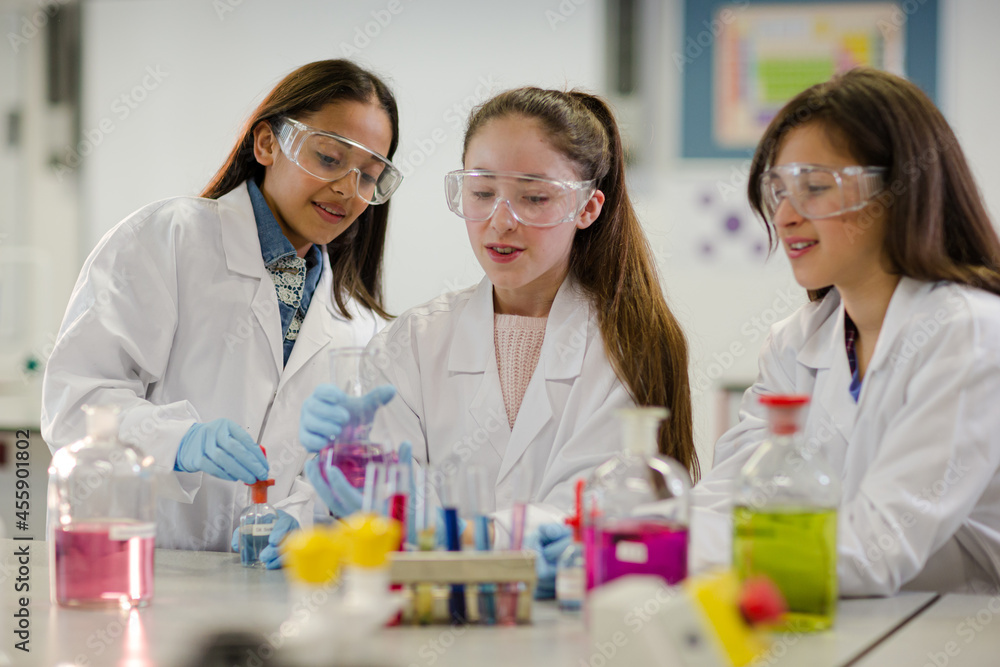 Girl students conducting scientific experiment in laboratory classroom Girl students conducting scientific experiment in laboratory classroom