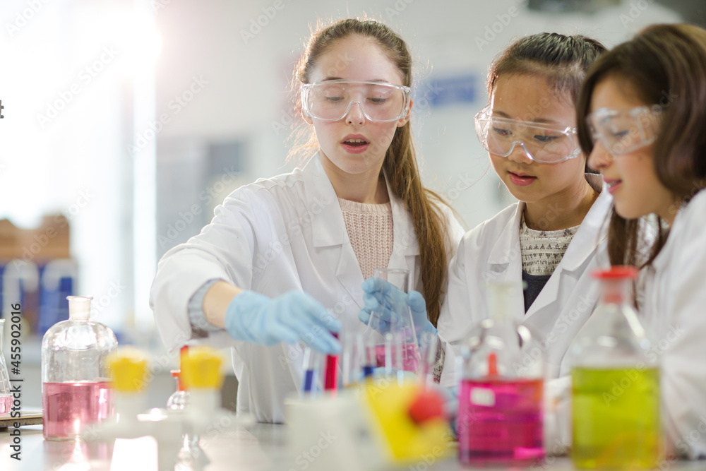 Girl students conducting scientific experiment in laboratory classroom Girl students conducting scientific experiment in laboratory classroom