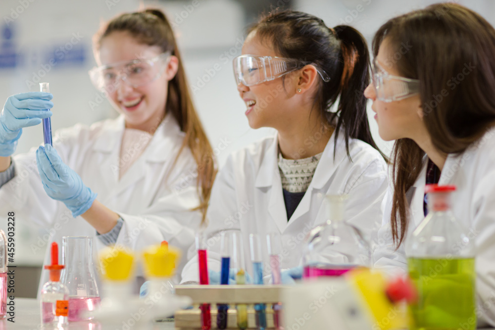 Girl students conducting scientific experiment in laboratory classroom Girl students conducting scientific experiment in laboratory classroom