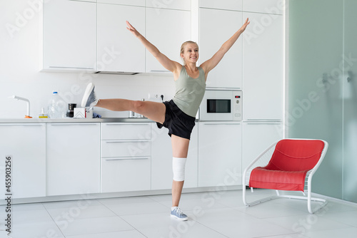 Smiling young woman working out at home, in the kitchen