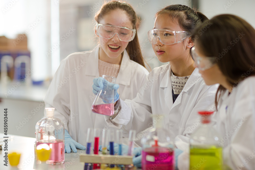 Girl students conducting scientific experiment in laboratory classroom Girl students conducting scientific experiment in laboratory classroom