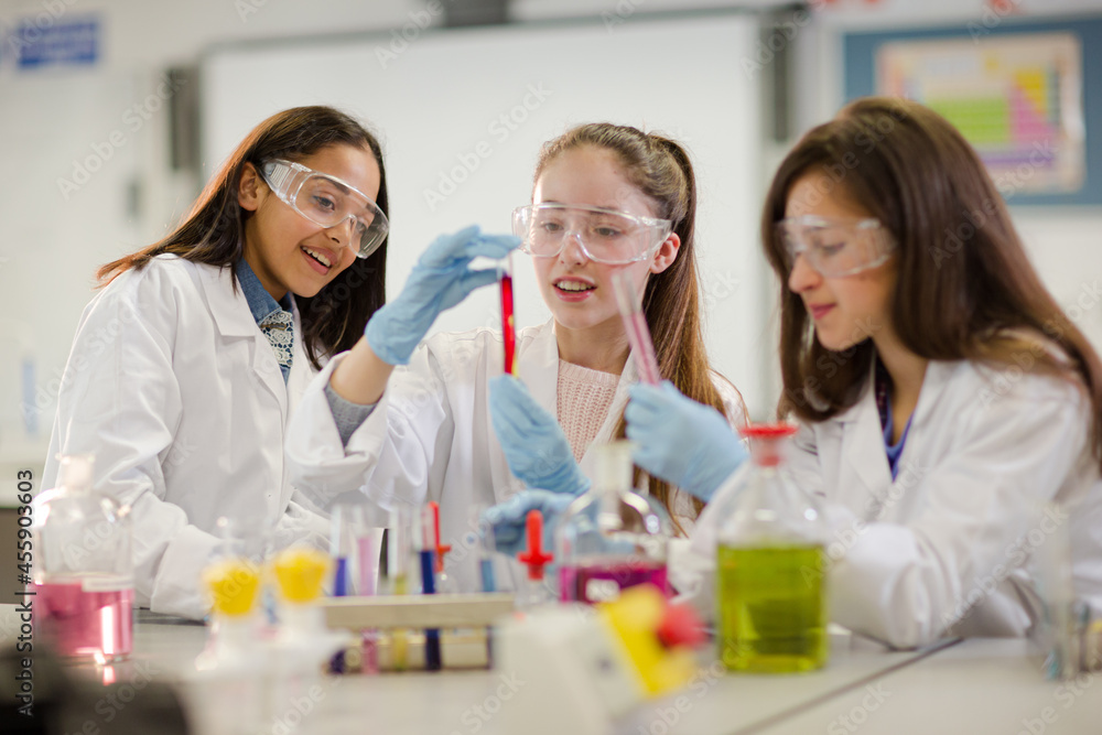 Girl students conducting scientific experiment in laboratory classroom Girl students conducting scientific experiment in laboratory classroom