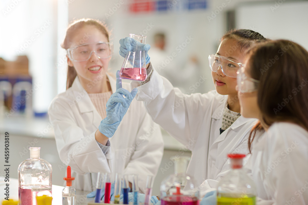 Girl students conducting scientific experiment in laboratory classroom Girl students conducting scientific experiment in laboratory classroom