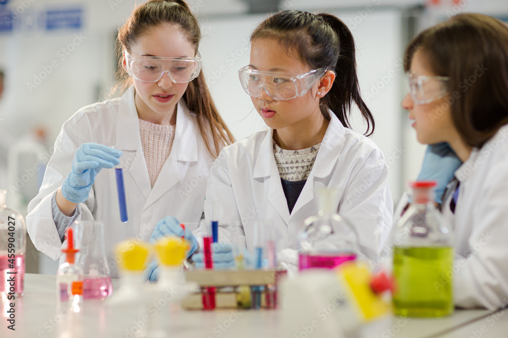 Girl students conducting scientific experiment in laboratory classroom Girl students conducting scientific experiment in laboratory classroom